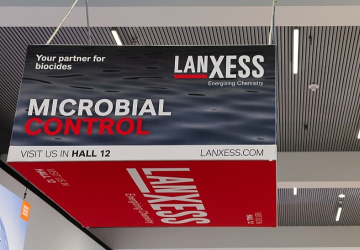 Close-up Image of a hanging cube, branded with Lanxess advertisement.