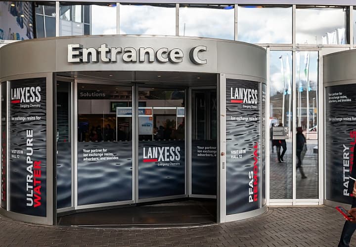 Image of the revolving doors at entrance C, branded with Lanxess advertising.