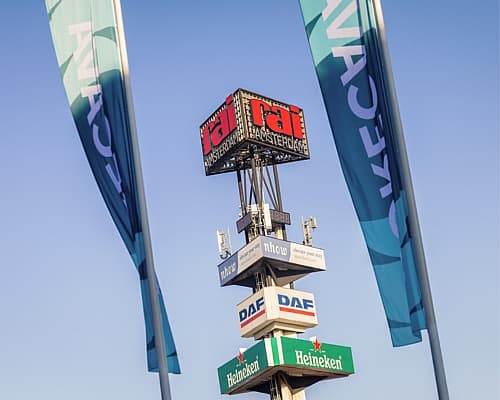 Driehoekige RAI Amsterdam toren met aan weerszijden Horecava vlaggen tegen een blauwe lucht