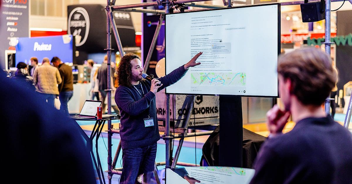 Spreker demonstreert AI-toepassing op groot scherm tijdens sessie op Horecava, met bezoekers die aandachtig meekijken.