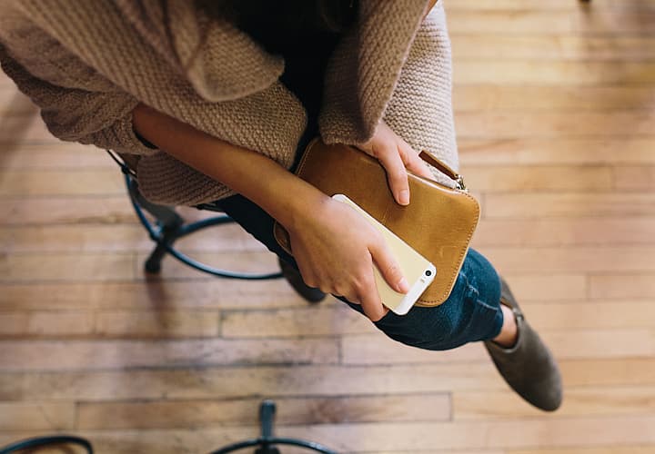 picture of a woman holding a phone and wallet